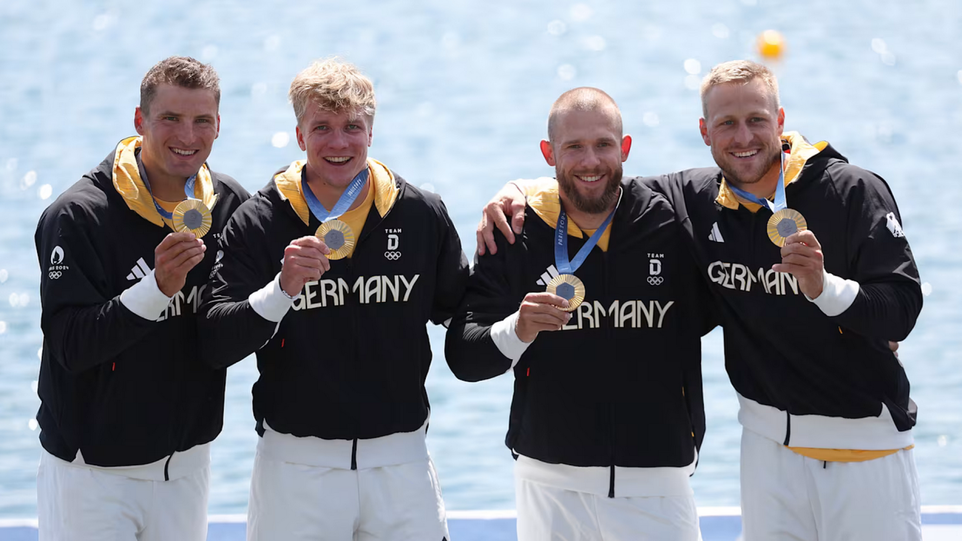 Das Bild zeit die deutsche Mannschaft im Kanu 4er mit olympischem Gold