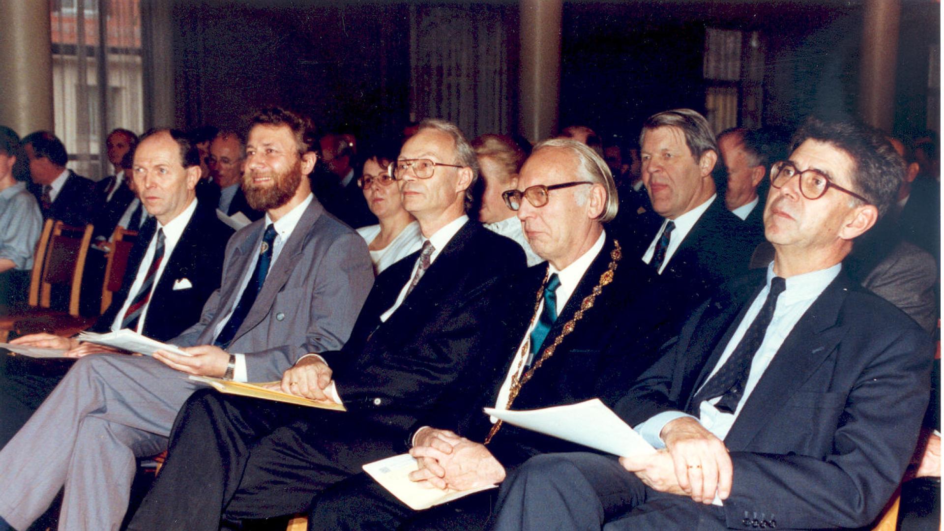 Men in suits siting in a row.