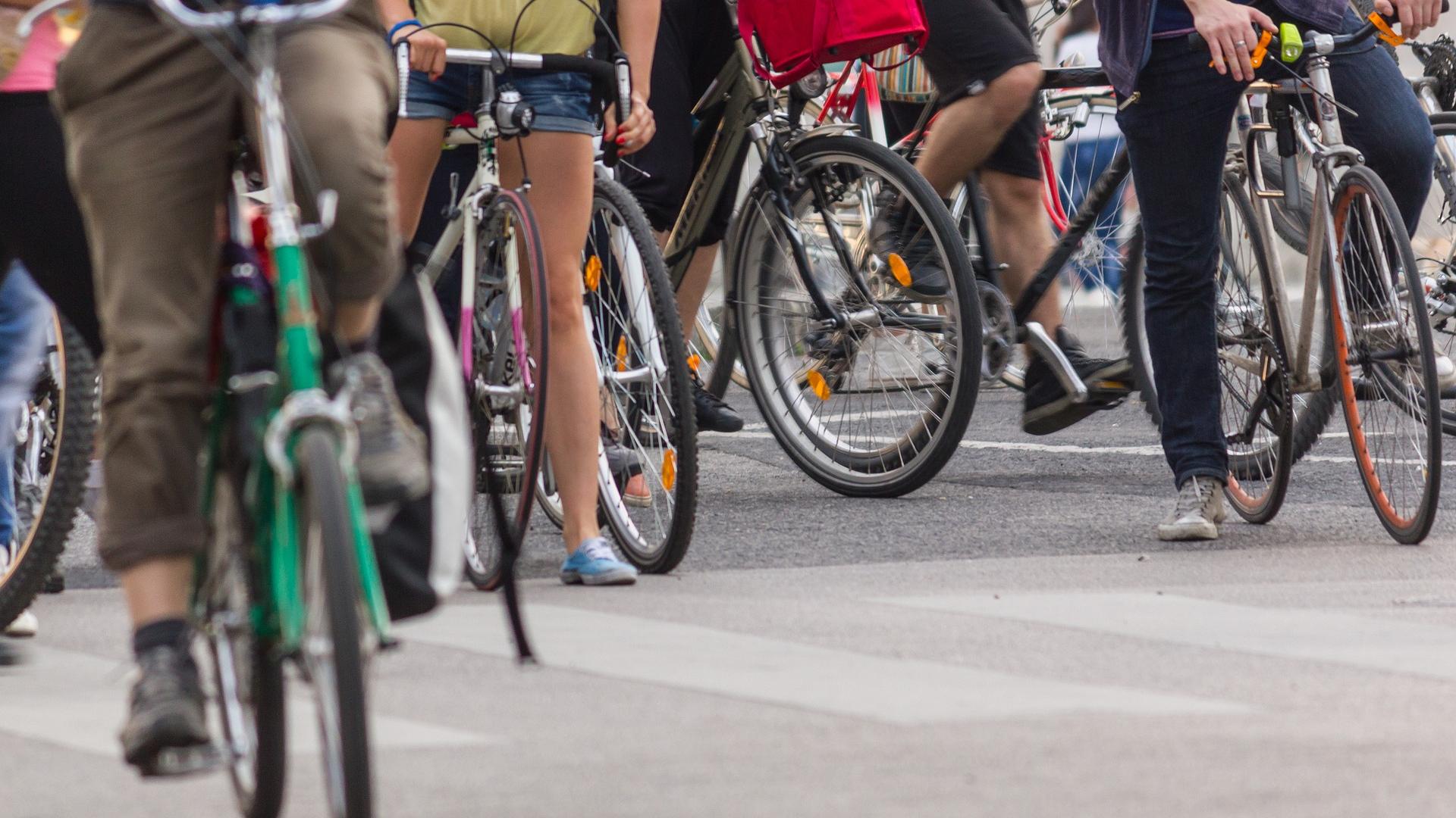 Serveral bycicles with people next to eachother
