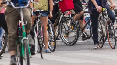 Serveral bycicles with people next to eachother