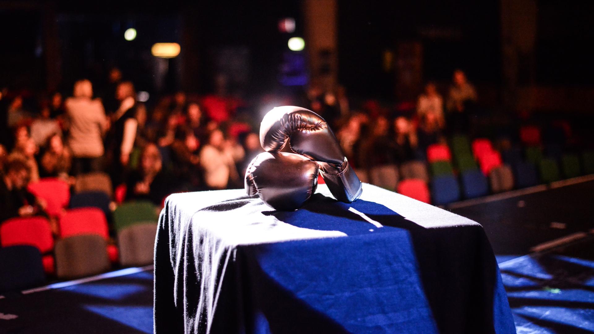 A stage with a table and boxing gloves on it