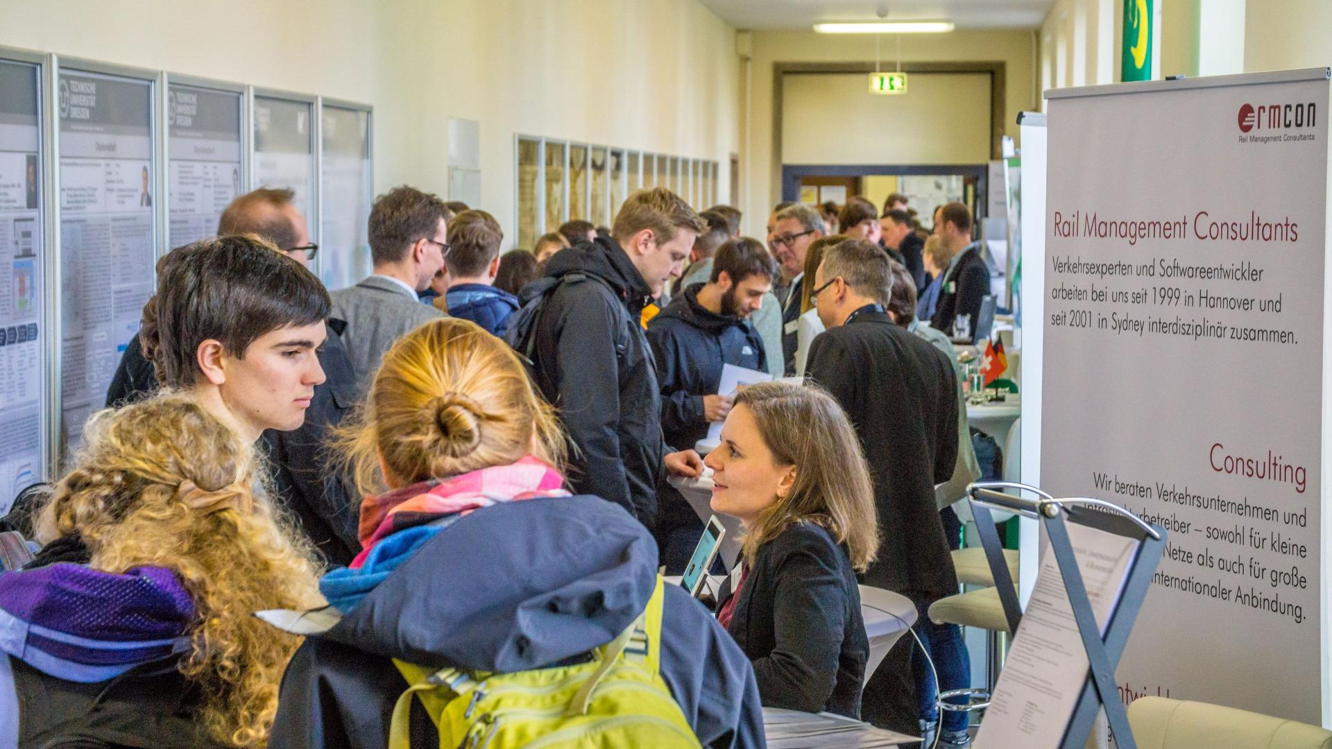 A corridor with exhibition stands and many people