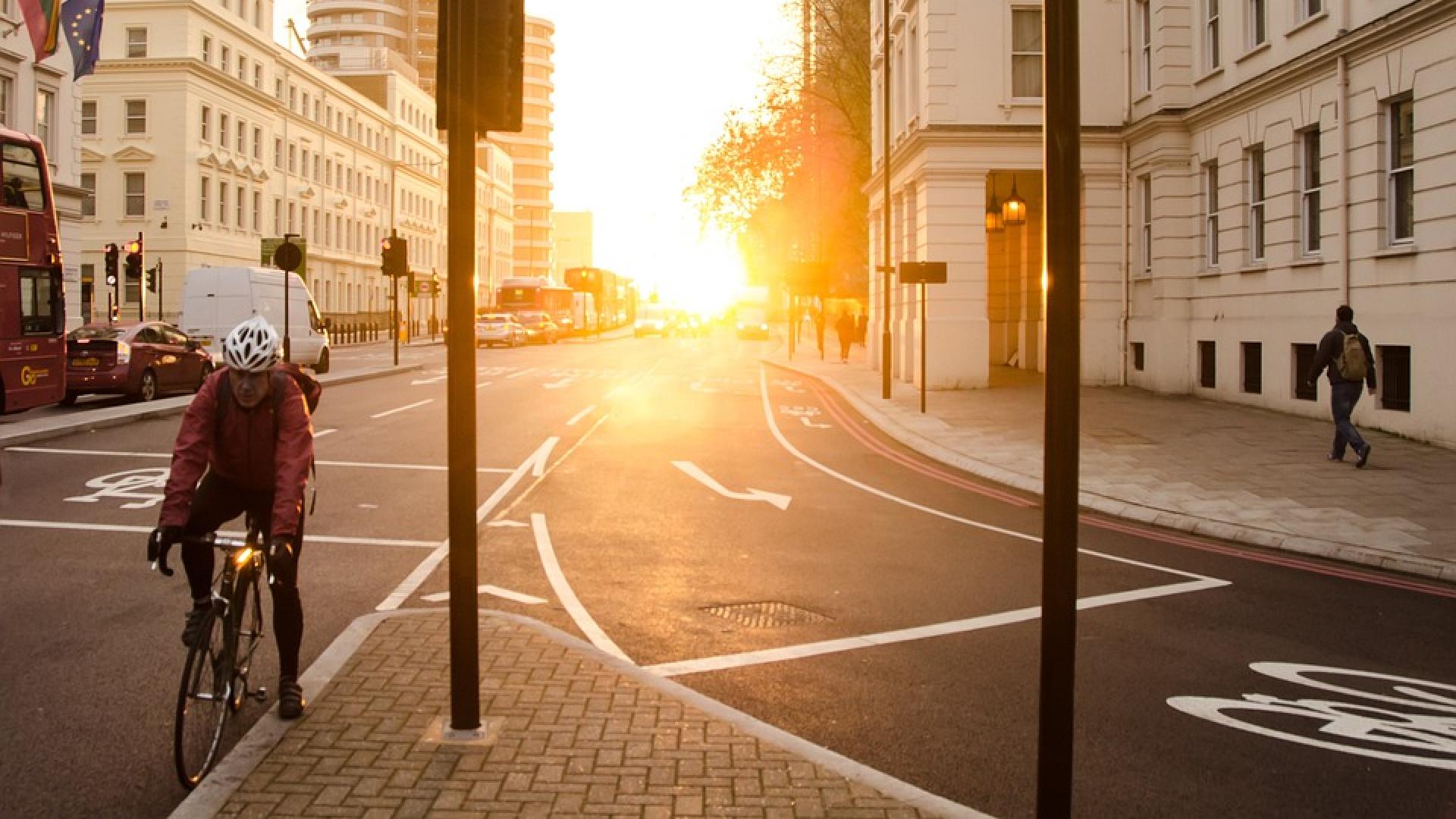 Bicyclist with helmet on road in front of sunrise