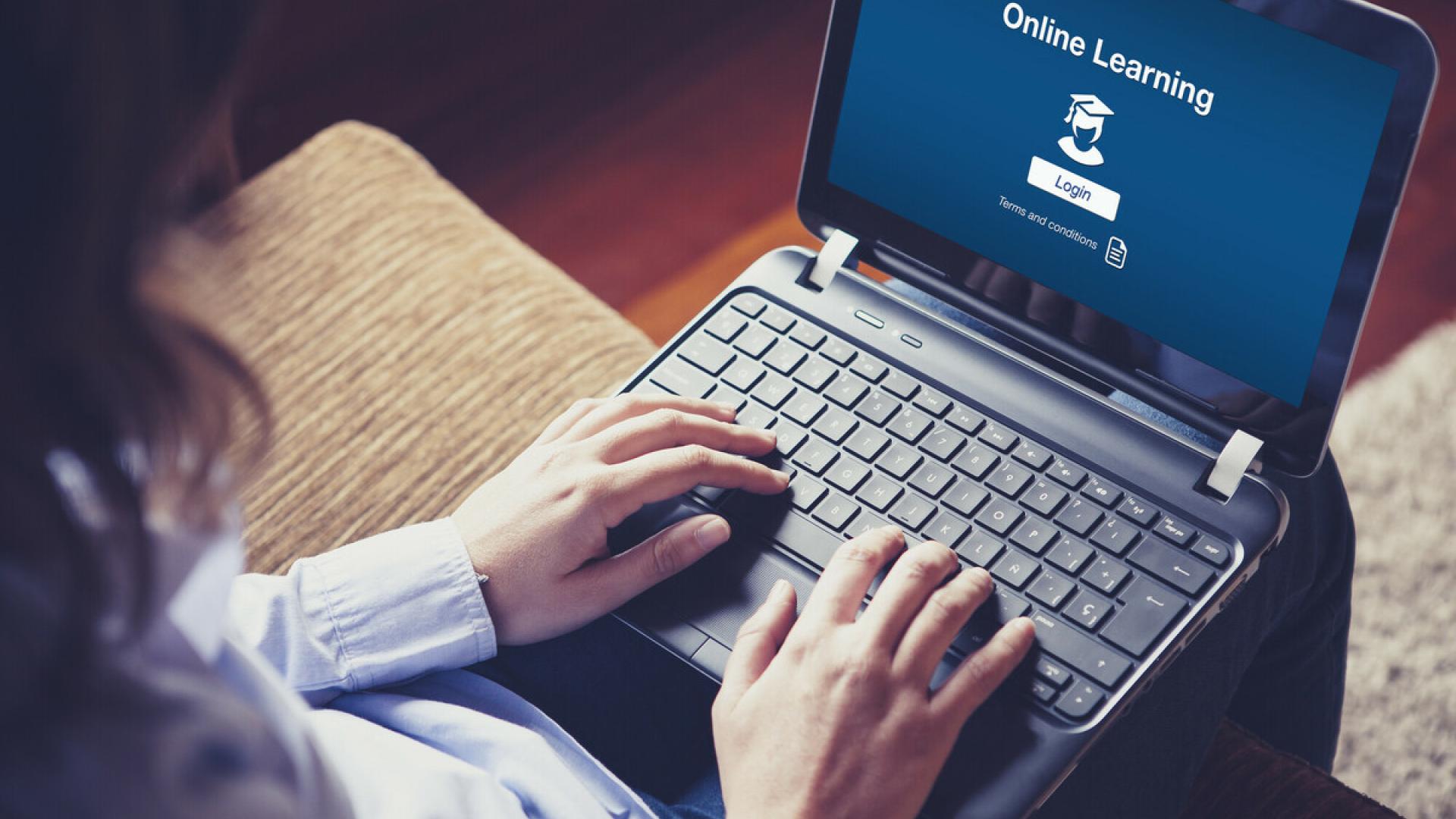 Das Foto zeigt eine Person mit einem Laptop auf dem Schoß.