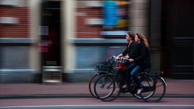 Zwei Frau auf Fahrrädern rollen durch die Stadt