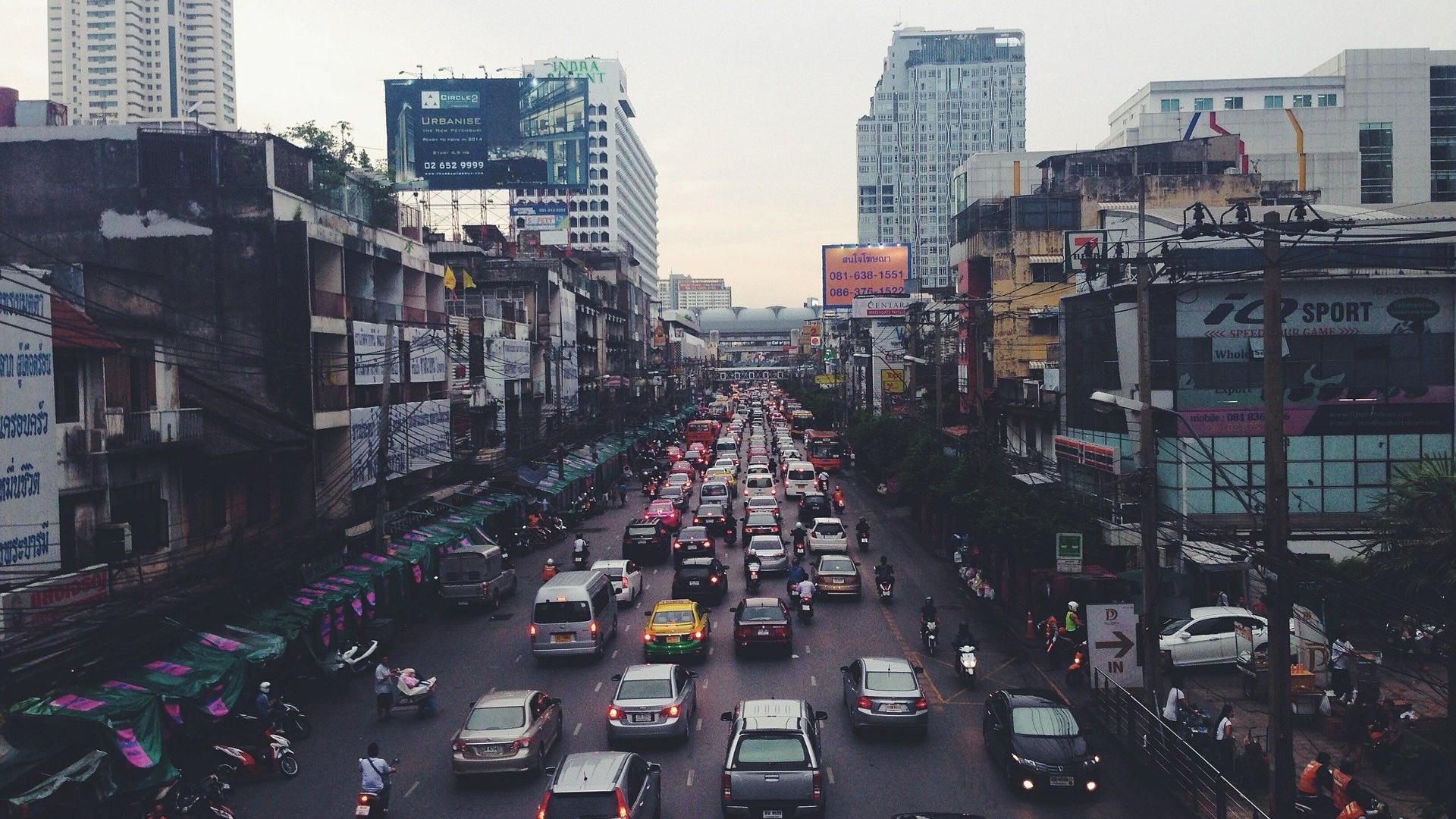 Urban canyons of a big city in India with traffic jams, cars, mopeds.