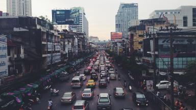 Urban canyons of a big city in India with traffic jams, cars, mopeds.