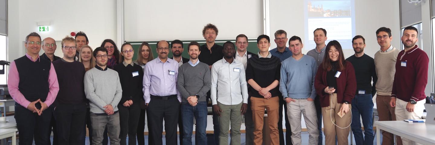 Ein Gruppenbild mit ca. 30 Personen in einem Seminarraum vor einer Tafel